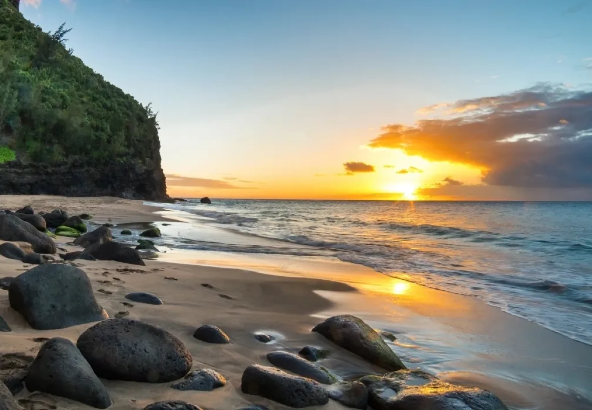 Sunset over rocky beach shoreline