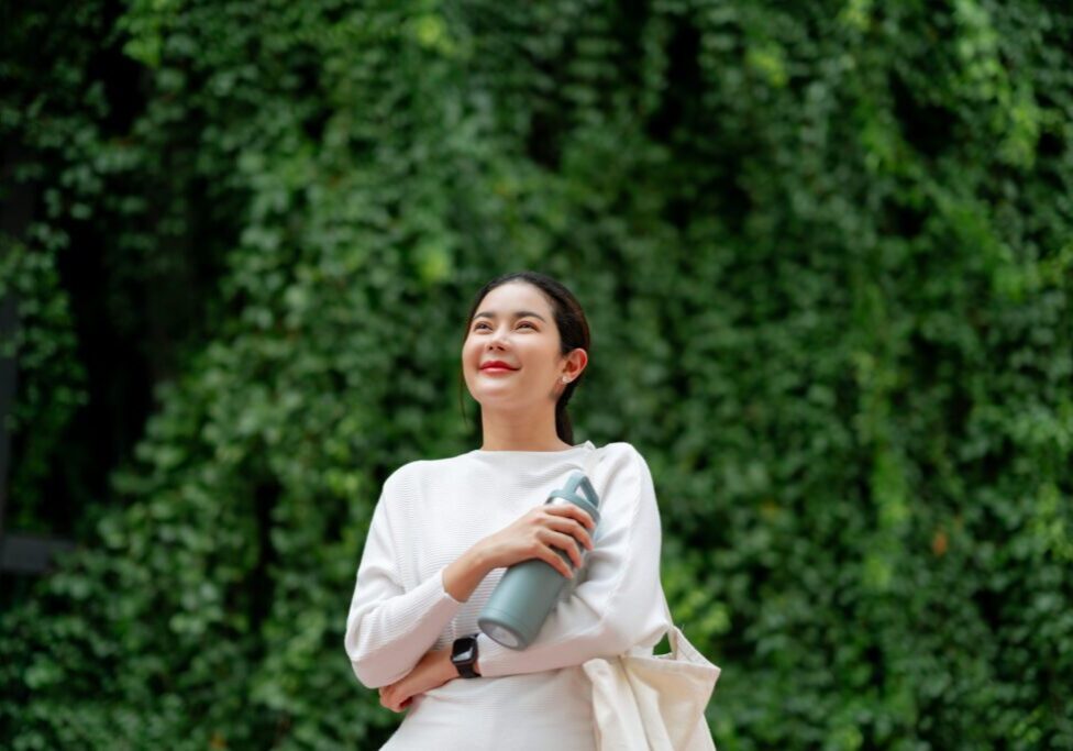 Person smiling with a water bottle outside