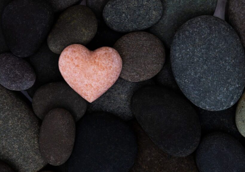 Heart-shaped stone among dark pebbles
