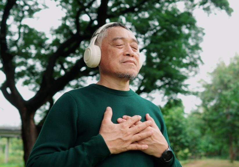 Relaxed man listening to headphones outdoors
